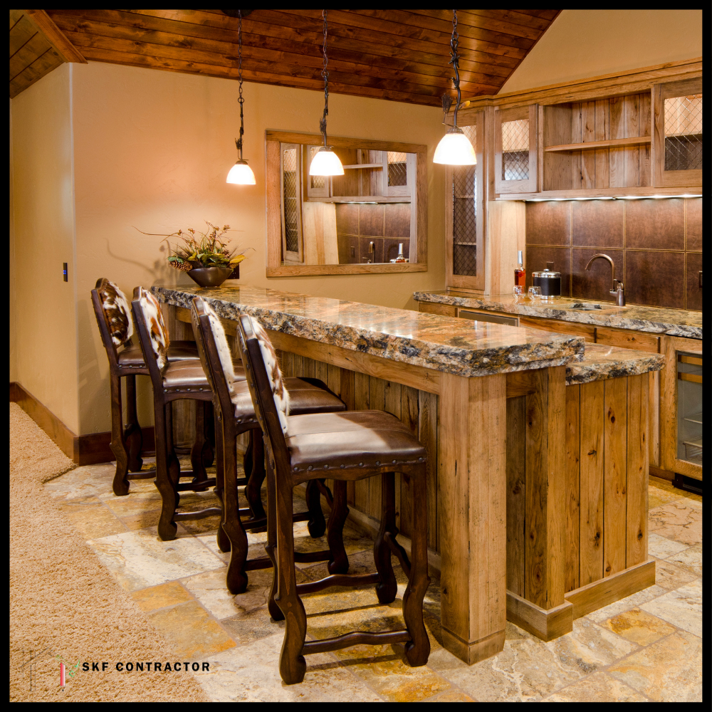 Reclaimed wood home bar with granite countertop, leather nailhead stools, chain pendants, and stone floor.