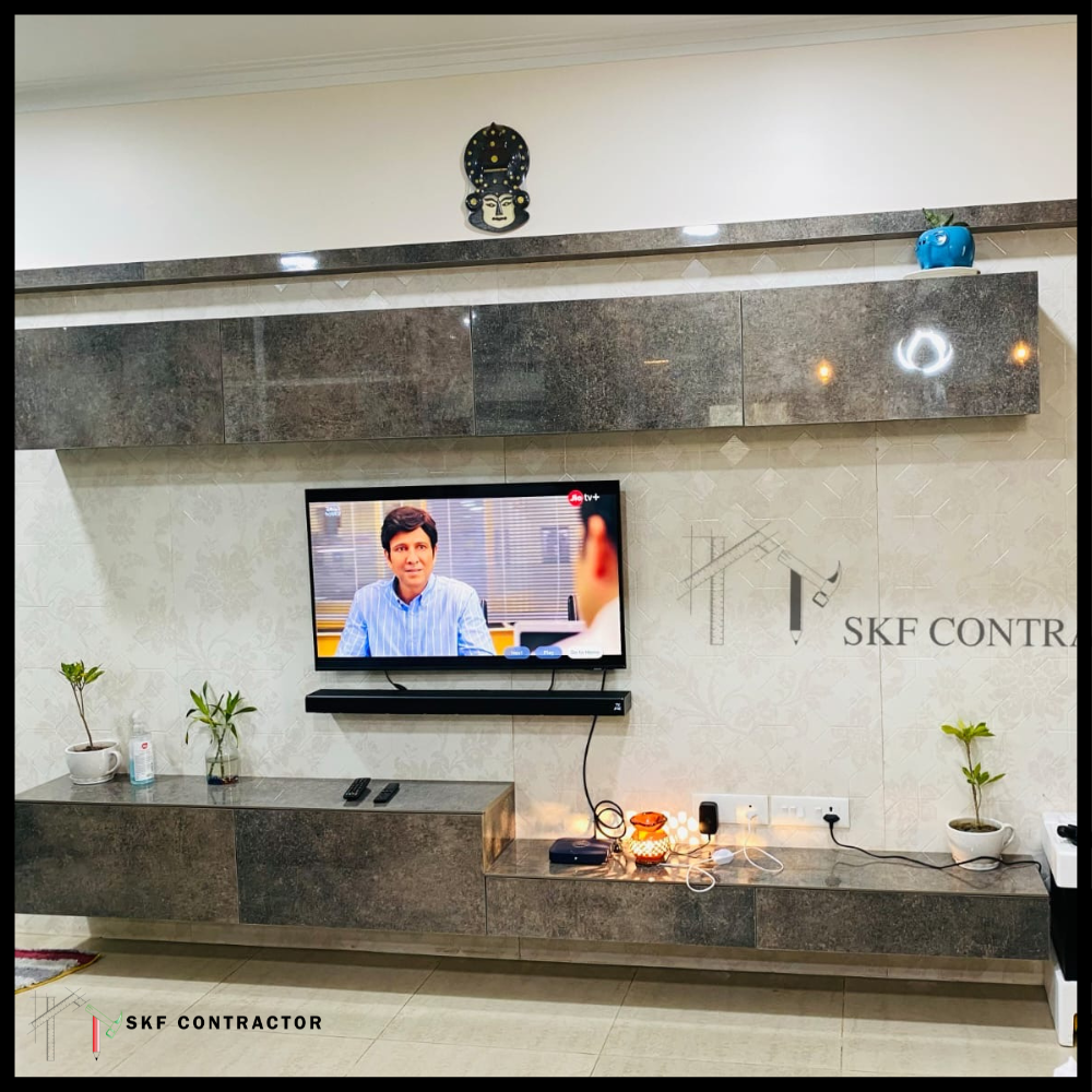 Floating TV unit with dark stone finish, wall-mounted cabinets and marble tile backdrop.