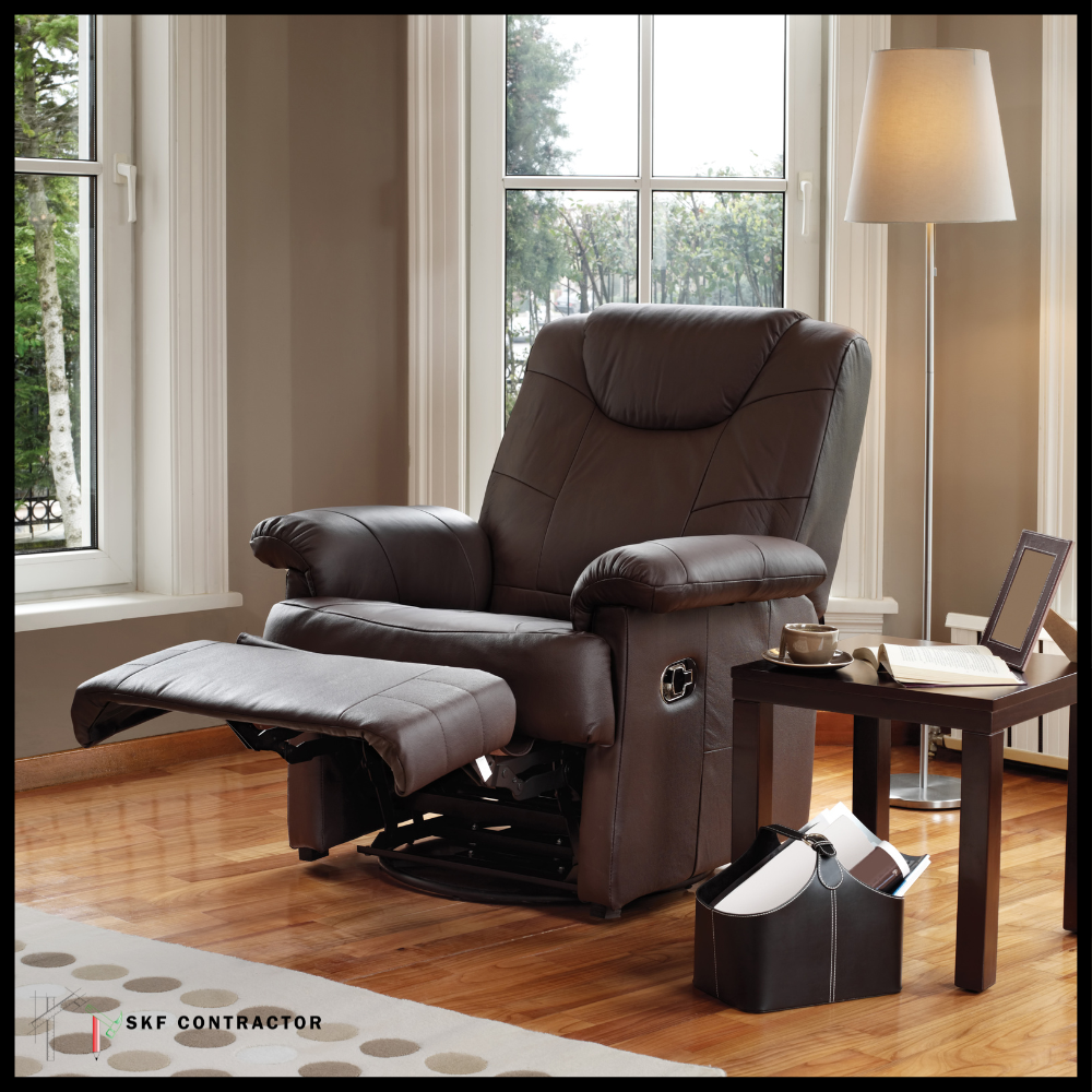 Dark brown leather recliner with extended footrest and padded armrests beside wood side table and floor lamp.
