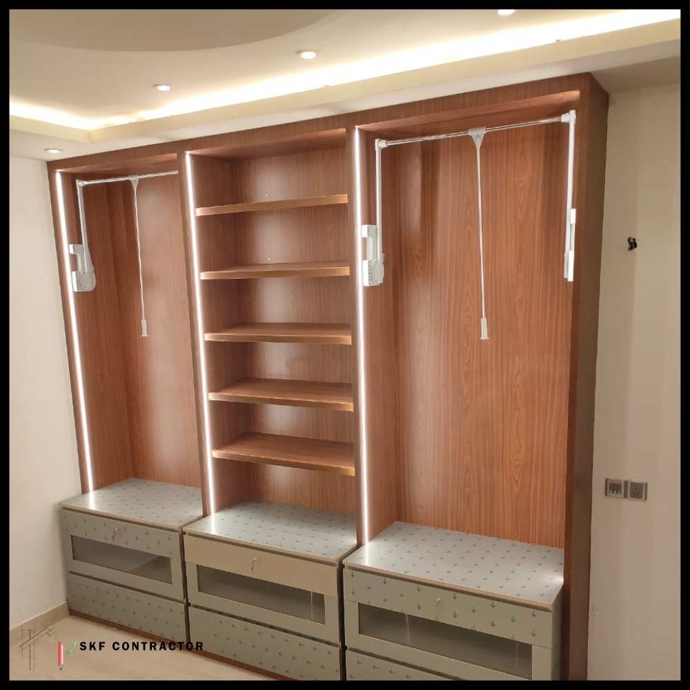 Open walk-in wardrobe with wooden finish, pull-down rods, shelves and LED strip lighting