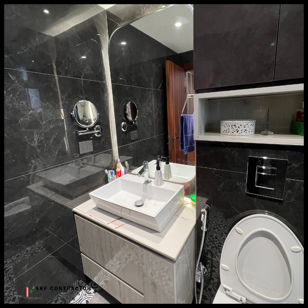 Black marble bathroom with wall-hung vanity, vessel sink, chrome swing mirrors, niche shelf, and wall toilet.