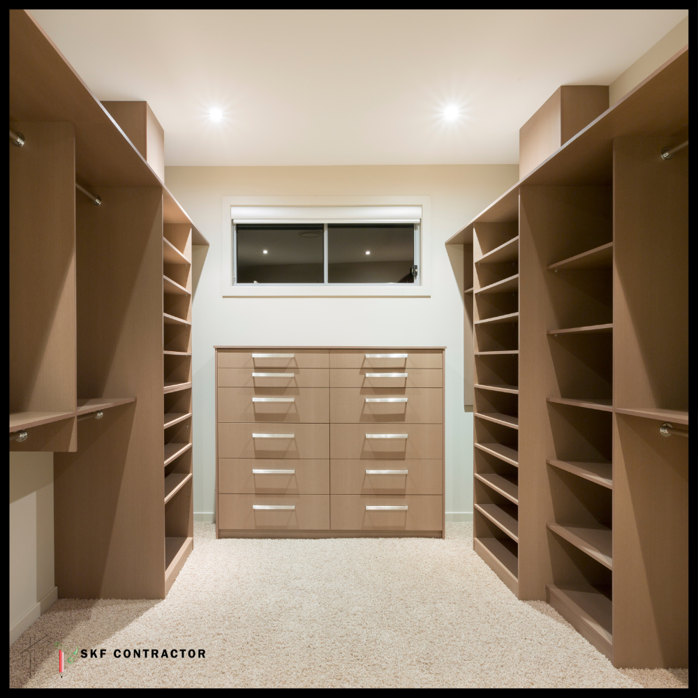 Spacious walk-in closet with floor-to-ceiling wooden shelves, hanging rods, and a center chest of drawers.