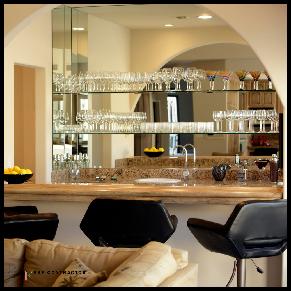 Home bar unit with granite top, mirrored shelves, crystal glassware, sink, and black leather bar stools.