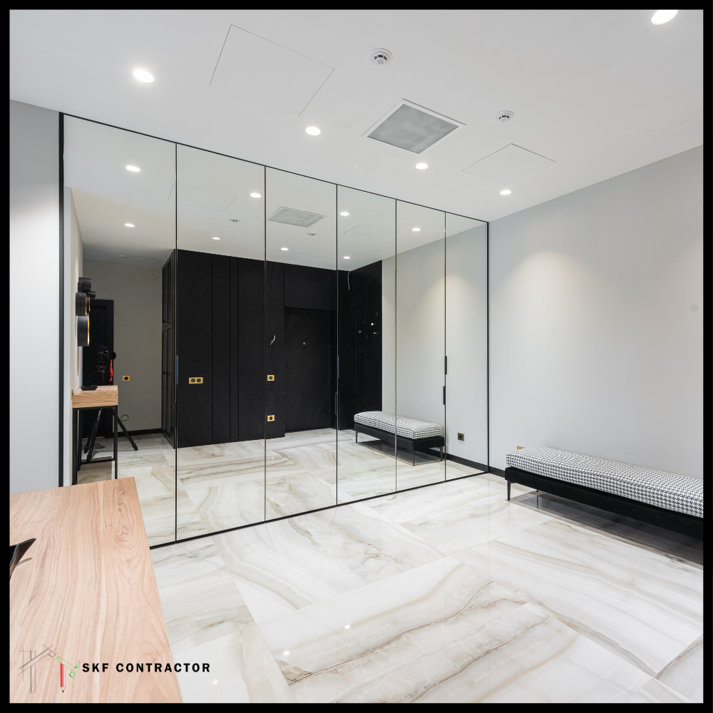 Full-height mirror wardrobe with black frame on marble floor in luxury bedroom.