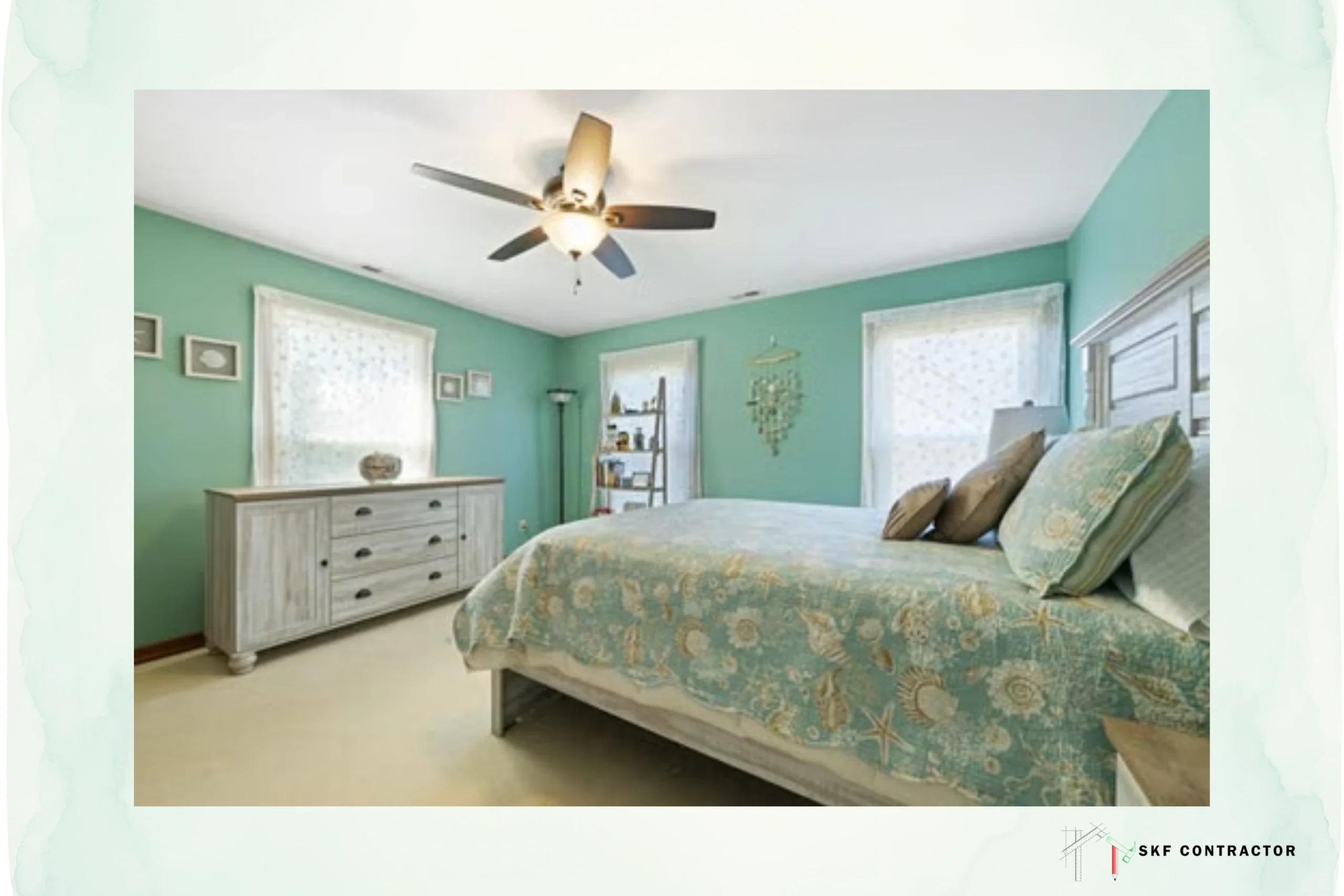 Bright coastal-style bedroom with teal walls, ceiling fan, patterned bed, dresser, windows, and soft natural light creating a calm, airy atmosphere.