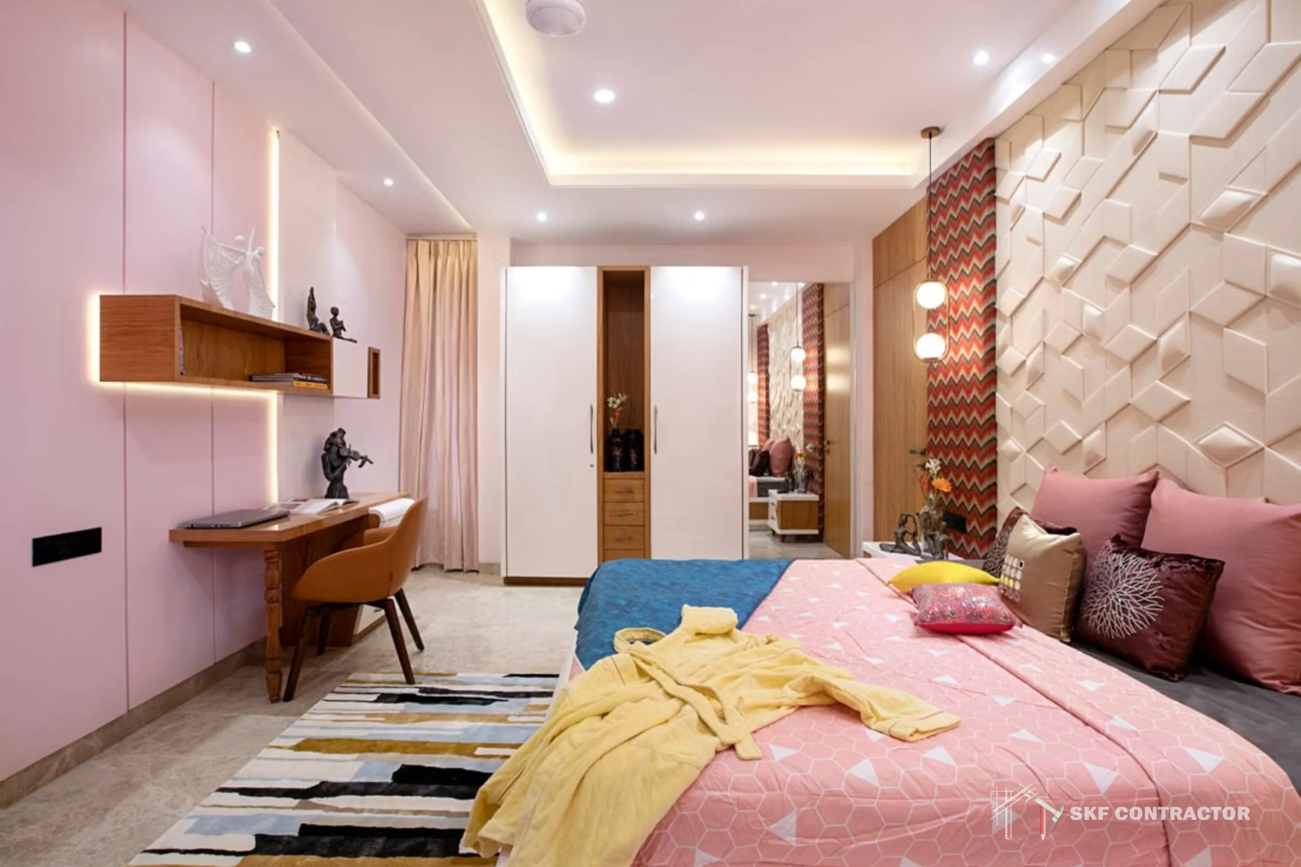 Modern pink bedroom with a geometric accent wall, patterned bed, yellow throw, wooden desk, shelves, and warm recessed lighting create a cozy feel.