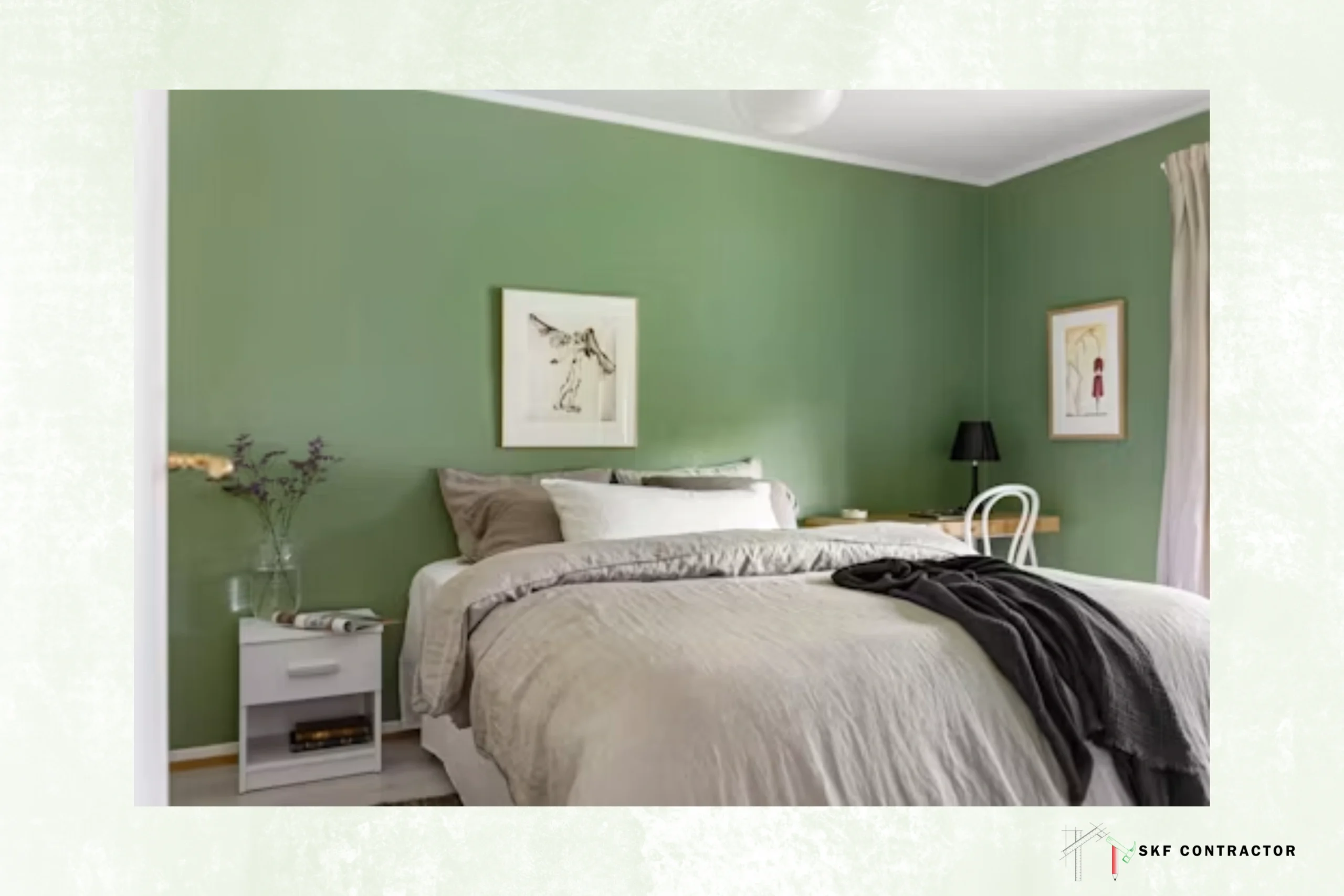 Serene bedroom with sage-green walls, a neatly made bed, charcoal throw, bedside table, framed artwork, lamp, and soft natural light.
