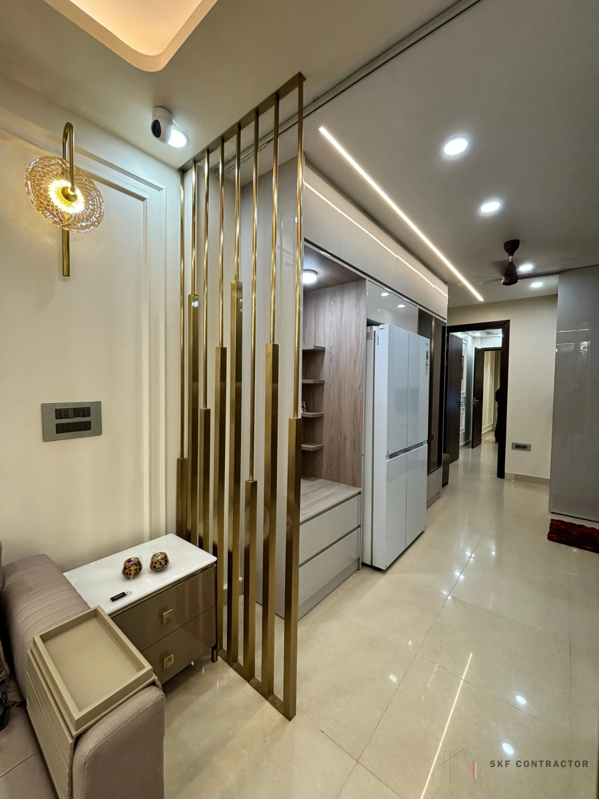 Brass partition and wall light in a Delhi home designed by SKF Contractor